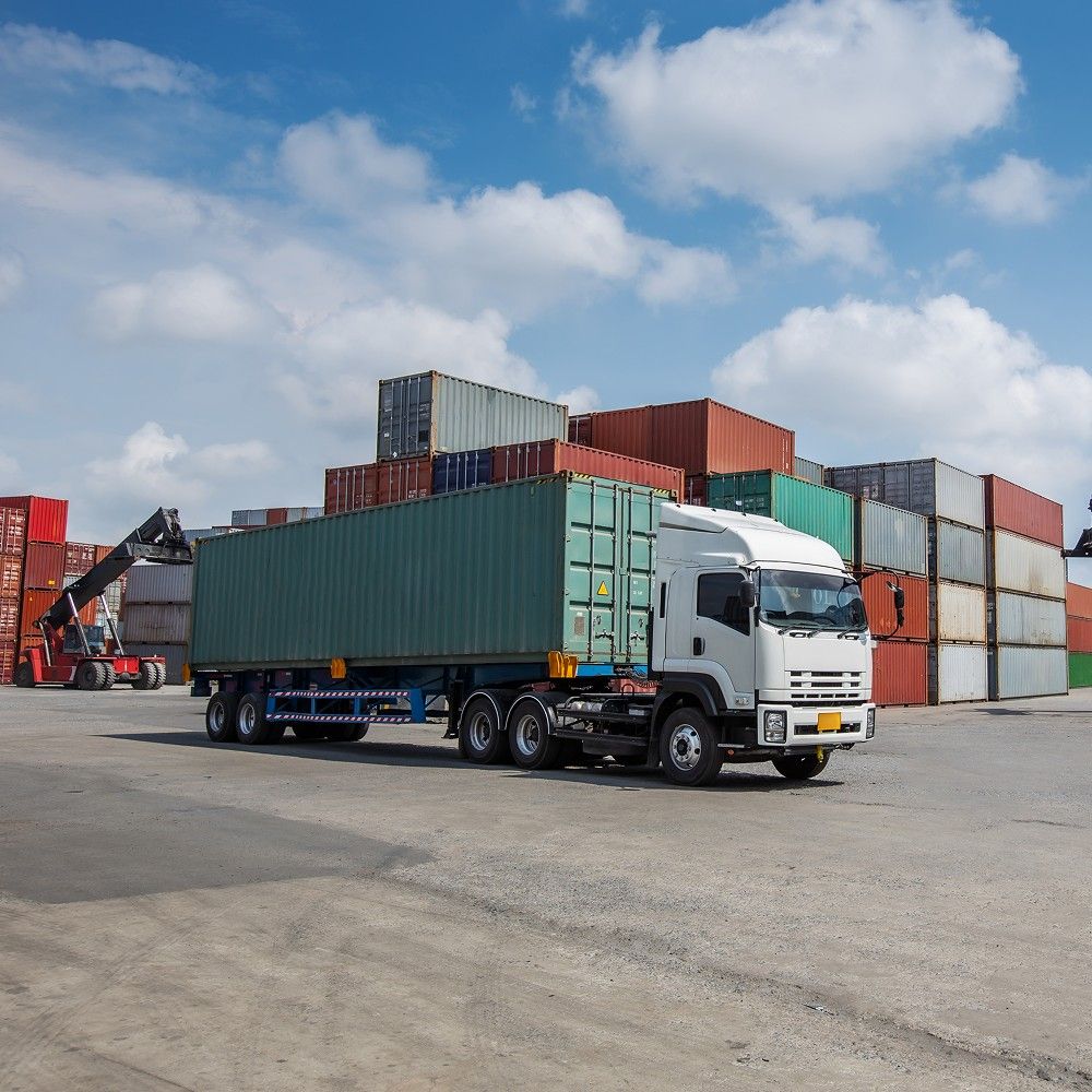 Shipping containers and a truck at a commercial port